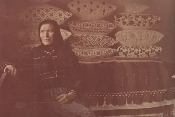 54.) Asszony (Balla Etelka édesanyja) a tisztaszobában, vetett ágy előtt. Feketelak, 1960-as évek