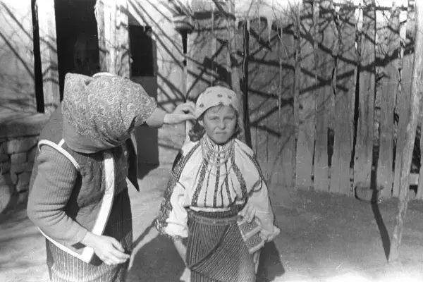 29.) Idős asszony kislány fejkendőjét igazítja. Moldva, 1980-as évek